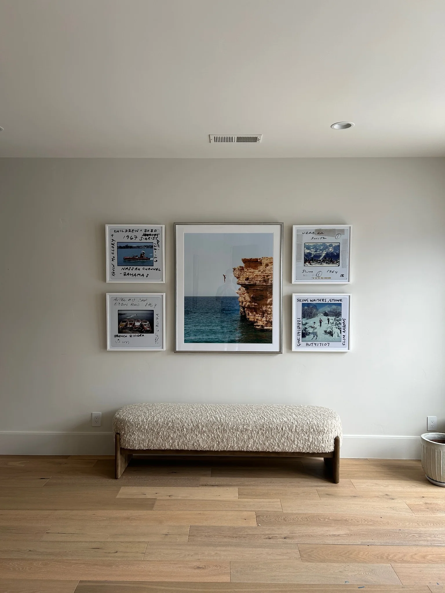 Professionally installed five-piece gallery wall above a bench
