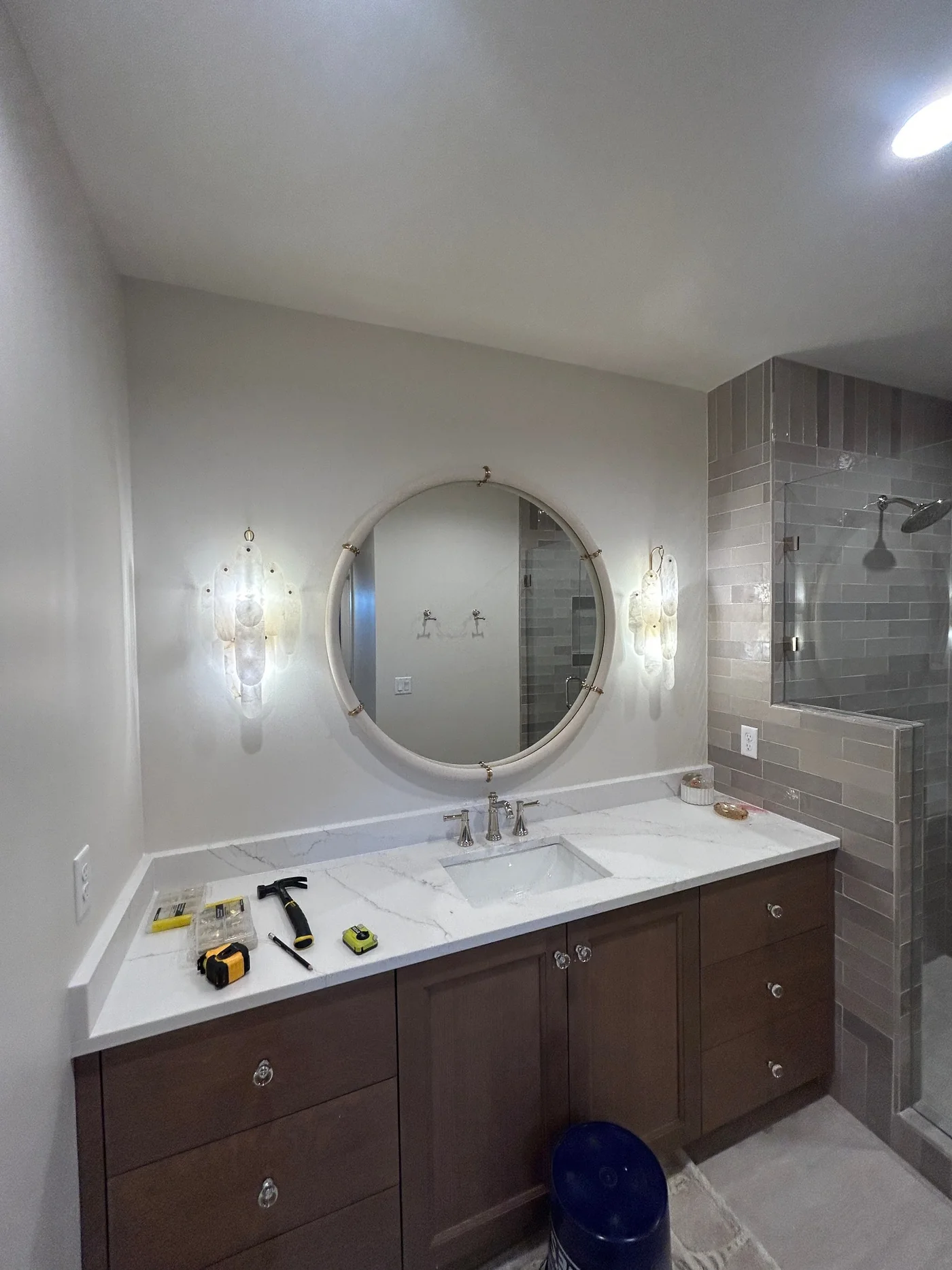 Large round mirror installed above a bathroom vanity